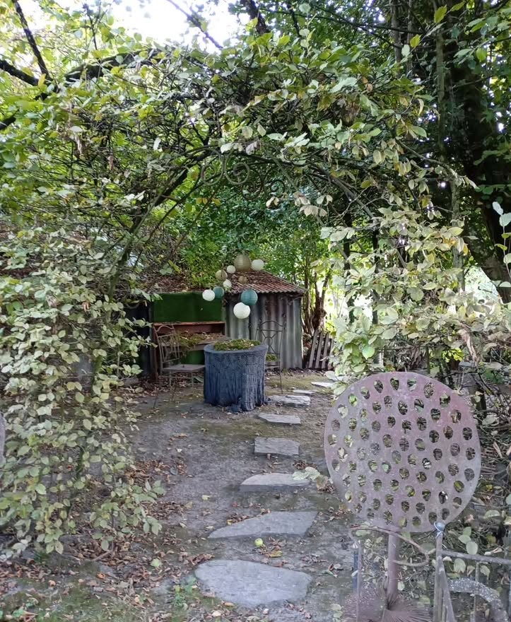 Allée en pas japonais sous une arche végétale dans un jardin privé à Bertrix