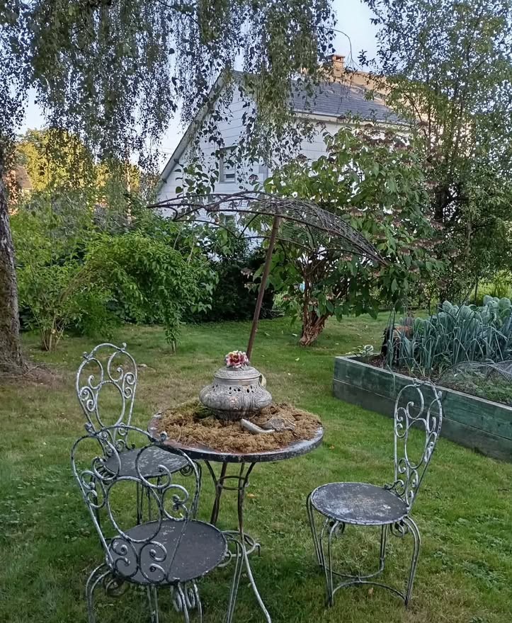 Table et chaises en fer forgé sur la pelouse d’un jardin de Bertrix
